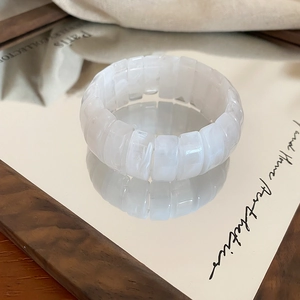 Close-up of cream marble resin stretch bracelet with thick rectangular blocks on mirror