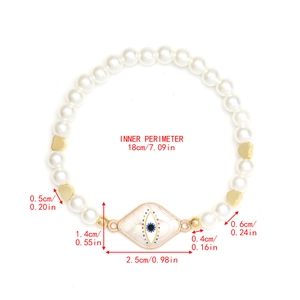 Detailed view of evil eye pendant and heart beads on a 18cm pearl beaded bracelet