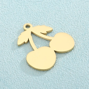 Golden cherry-shaped titanium steel pendant for jewelry making on blue background