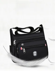 Detail view of lightweight black nylon crossbody bag with multi-zippered pockets