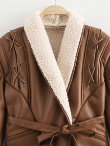 Détail du manteau en cuir marron avec doublure en fausse fourrure crème et laçage décoratif