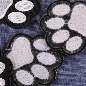 Embroidered animal paw patches in black, white, and gray for clothing and caps