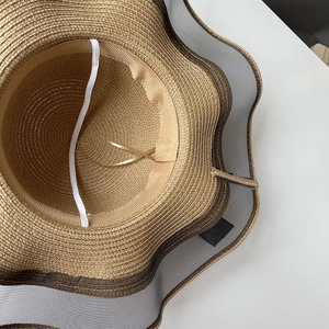 Wide brim straw sun hat for women featuring elastic chin strap and inner sweatband