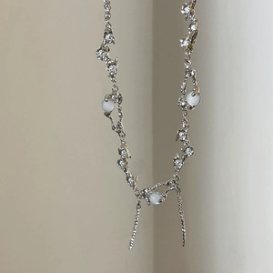 Detail of silver beaded necklace with white pearls, small crystals and dangling chains