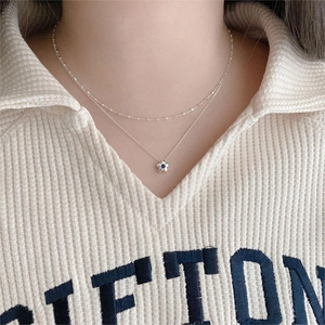 Model wearing a double-layer 925 silver necklace featuring a blue gemstone flower pendant