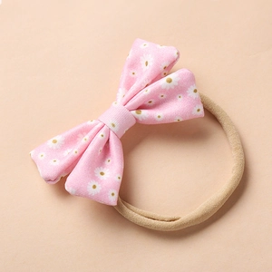 Detailed macro view of pink floral daisy print bow on soft nylon baby headband