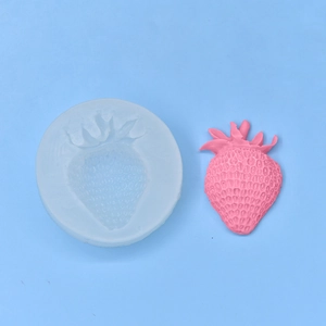 Stampo in silicone a fragola con candela rosa finita su uno sfondo azzurro