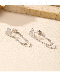 Close-up of S925 silver heart tassel earrings with sparkling zircons on a textured surface