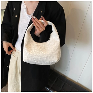 Detail of white woven hobo bag with Intrecciato pattern and top metal zipper closure