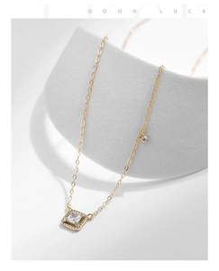 Macro detail of S925 silver gold sugar cube necklace with sparkling square pendant