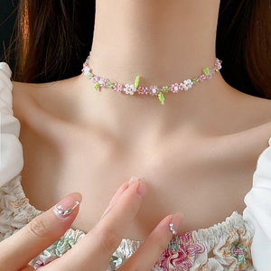 Detailed macro view of handmade floral seed bead necklace with pastel flower patterns