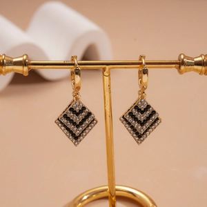 Detailed view of luxury geometric diamond earrings with a gold base and checkered pattern