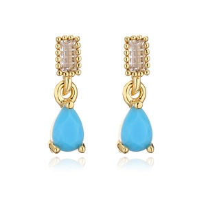 Macro view of 18K gold teardrop earrings with turquoise stones and clear crystals