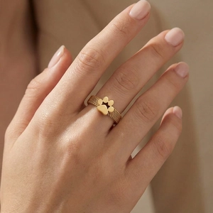Detailed view of a gold mesh band ring with a cute cat paw design on a model finger