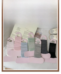 Flat lay of knit leg warmers in various colors including white, pink and blue