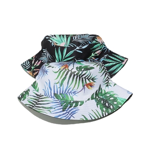 Detail view of tropical leaf patterns on black and white cotton bucket hats