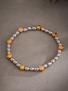 Detail of two-tone hammered beads and gold flower charm with micro-pave cubic zirconia