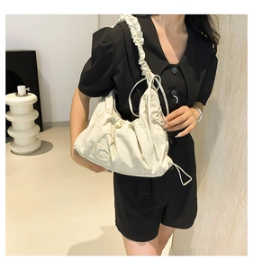 Detail of cream nylon cloud bag with ruffled shoulder strap and drawstring texture