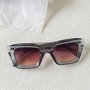 Detail of square smoke grey sunglasses with purple to orange gradient lenses