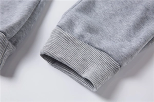 Gros plan sur le tissu en maille grise montrant la texture et les poignets côtelés élastiques
