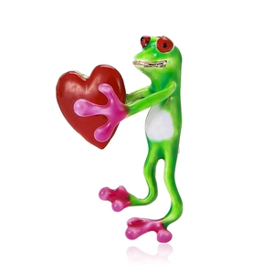 Enamel frog brooch holding a red heart with pink accents on polished metal