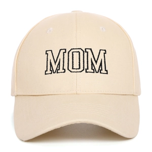 Detailed close-up of MOM embroidery on the front of a beige cotton baseball cap