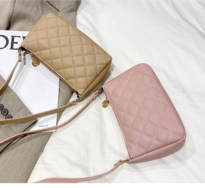 Close-up of khaki and pink quilted crossbody bags with detailed diamond stitching