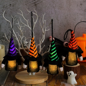 Set of four glowing Halloween gnome ornaments with colorful striped hats and warm LED lights