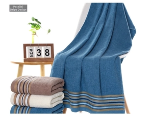 Detail of soft cotton towels with colorful stripes stacked and draped in a home setting
