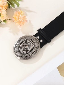 Close-up of vintage American style black leather belt with embossed silver metal buckle