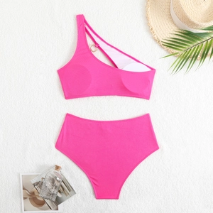 Close-up of pink ribbed bikini set with gold metal ring and one-shoulder chain detail
