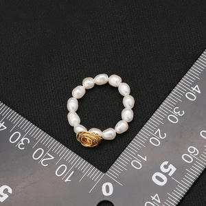Anello con perla naturale d'acqua dolce e design a rosa in filo dorato su nero