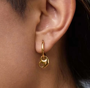 Close-up of model wearing small 18k gold-plated stainless steel heart hoop earrings