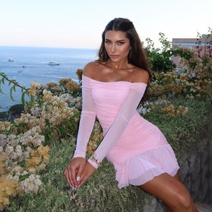 Détail de robe froncée en mesh rose à épaules dénudées avec manches longues pour vacances