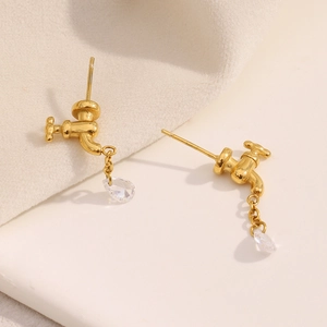 Macro shot of 18K gold faucet earrings featuring a clear teardrop-shaped zircon drop