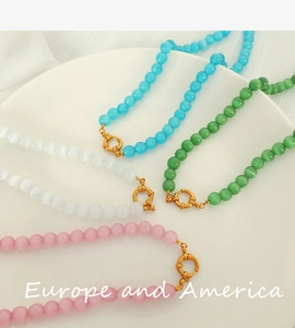 Detail of colorful faceted cat eye stone beaded necklaces with golden round clasps