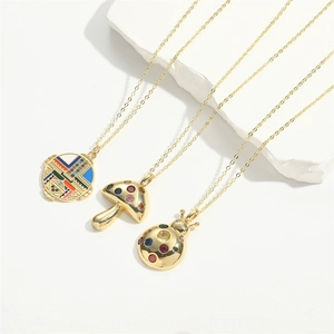 Golden necklace set with colorful mushroom, beetle, and geometric disc charms on stone