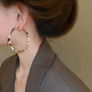 Close-up of large hoop earring with black and white texture and gold metal splice