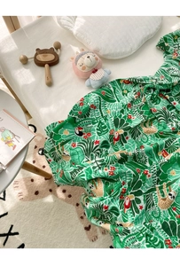 Detail of bamboo cotton muslin baby swaddle with tropical sloth and toucan print