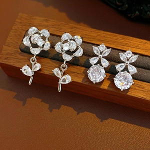 Détails macro de boucles d'oreilles fleur argentées avec zircone sur présentoir