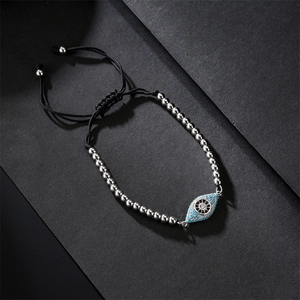 Macro detail of copper beads and colorful zircon evil eye charm on adjustable bracelet