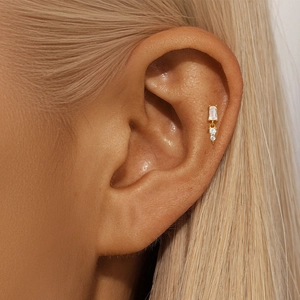 Detailed view of a gold-plated silver earring with sparkling cubic zirconia on an ear