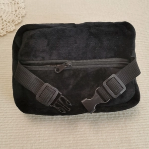 Close-up of black plush tissue holder with metal zipper and adjustable plastic buckle