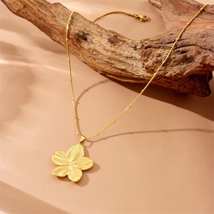 Collier avec pendentif fleur vintage plaqué or et chaîne serpent sur branche naturelle