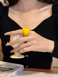 Close-up of a bold yellow resin square ring styled with a modern minimalist aesthetic