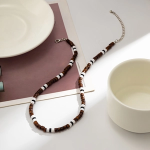 Detail of bohemian necklace featuring brown wood beads with lobster clasp and chain