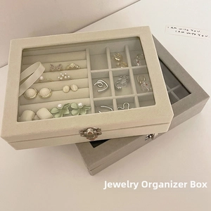 Close-up of velvet jewelry organizer with glass lid, metal lock and grid compartments