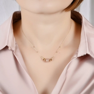 Elegant gold stainless steel necklace with pink gemstone pendant shown on a model