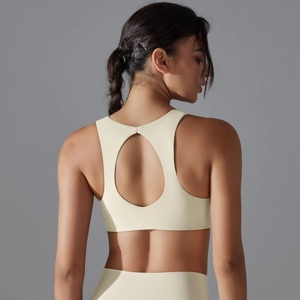 Cream sports bra featuring a hollow out open back design and matte high-stretch fabric