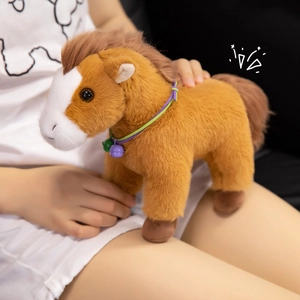 Plush brown horse doll with white face patch and a purple bell collar in warm home setting